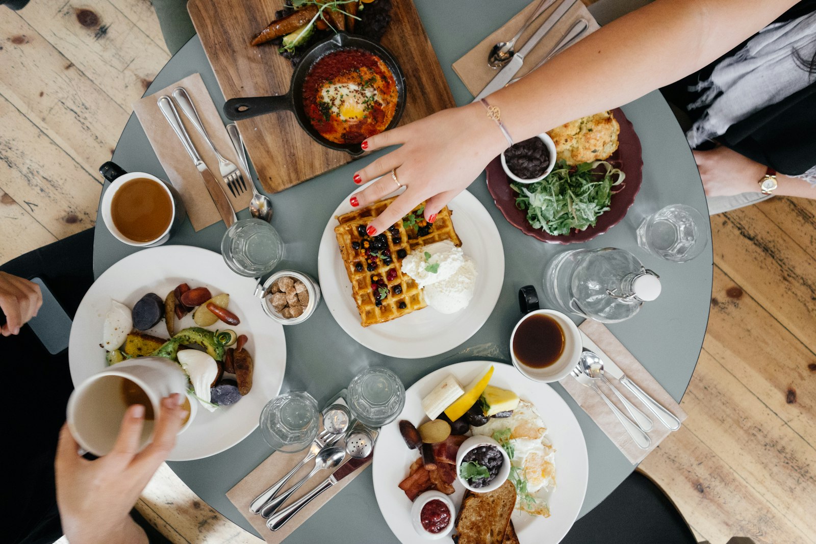 Mesa de desayuno con café, huevos, fruta y waffles